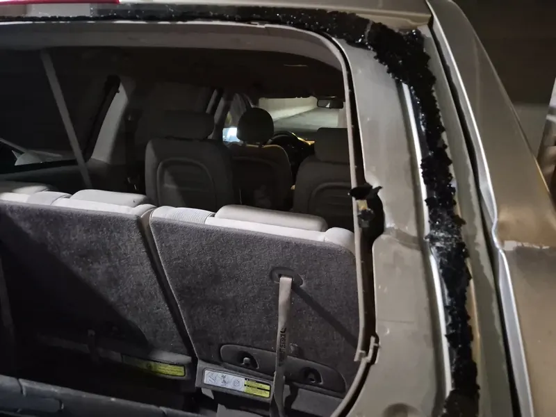 SUV rear window frame with shattered glass before replacement
