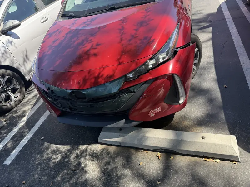 Red Prius with front-end collision damage as it arrived at the shop